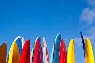 Image showing Stack of surfboards by seaside
