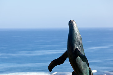 Image showing Statue of whale breaching with sea