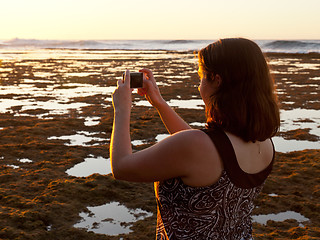 Image showing Girl taking photo of sunset on phone