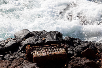 Image showing Old engine block dumped by sea