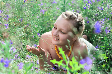 Image showing Young girl lying among the flowers