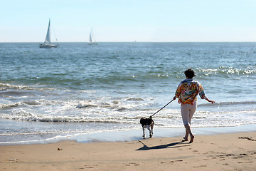 Image showing Woman with a dog on the beach