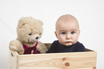 Image showing young child with toy in wooden box