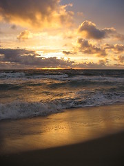 Image showing Sunset at beach with an isle in the horizon