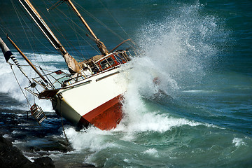 Image showing yacht crash on the rocks in stormy weather 