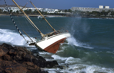 Image showing yacht crash on the rocks in stormy weather 