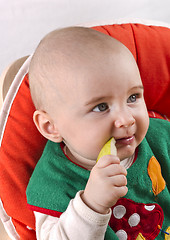 Image showing baby sitting and eating an apple