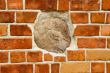 Image showing Big stone in red brick wall. Architecture closeup 
