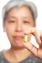 Image showing mature woman holding pill