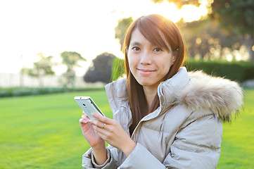 Image showing young woman with phone outdoors