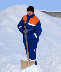 Image showing The worker removes the snow