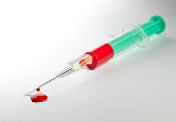 Image showing syringe laying on table filled with blood