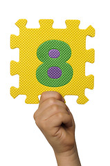 Image showing Children hand holding the number Eight. White isolated number