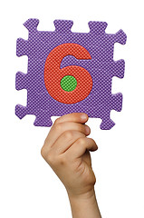 Image showing Children hand holding the number Six. White isolated number