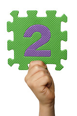 Image showing Children hand holding the number Two. White isolated number