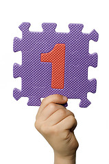 Image showing Children hand holding the number One. White isolated number
