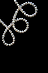 Image showing White pearls on the black silk as background 