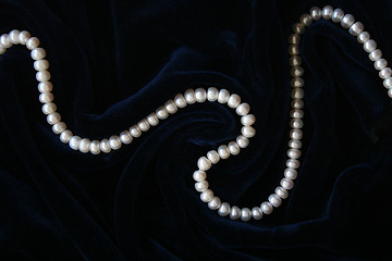 Image showing White pearls on the black silk 