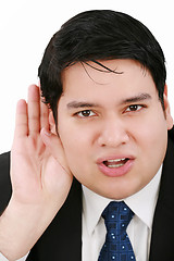 Image showing Young business man listening something isolated on white background