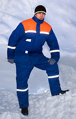 Image showing An employee in a warm suit on the street. Much snow