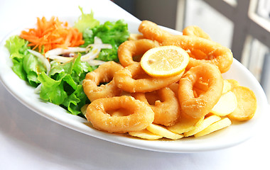 Image showing Deep batter fried squid rings calamari with green salad 