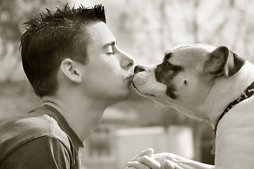 Image showing Boy kissing his dog