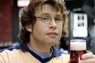 Image showing Young man holding a glass of beer