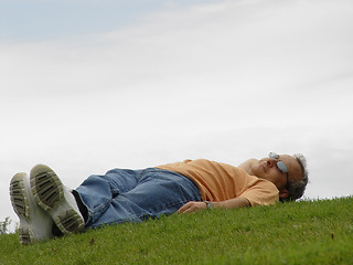 Image showing A man lying on the grass