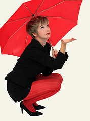 Image showing Businesswoman with a red umbrella looking up