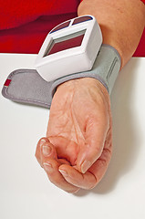 Image showing pensioner is measuring her blood pressure