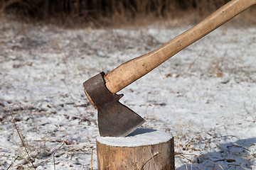 Image showing Axe and log in winter forest