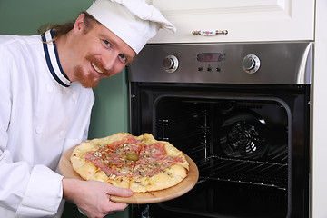 Image showing young chef with italian pizza in kitchen