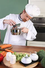 Image showing Funny young chef strange looking at pot