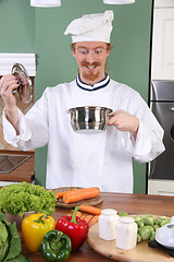 Image showing Funny young chef strange looking at pot