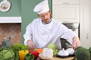 Image showing Young chef preparing lunch in kitchen