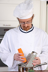 Image showing Young chef preparing lunch in kitchen