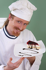 Image showing Young chef with piece of cake