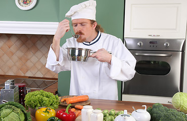 Image showing young Chef tasting food with a tablespoon