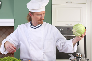 Image showing Young chef preparing lunch in kitchen