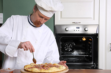 Image showing Young chef prepared italian pizza in kitchen