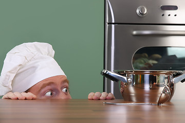 Image showing Funny young chef strange looking at pot