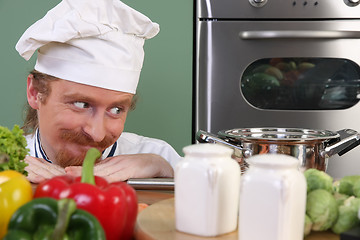 Image showing Young chef preparing lunch in kitchen 