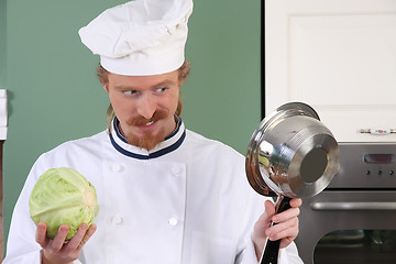 Image showing Young chef preparing lunch in kitchen