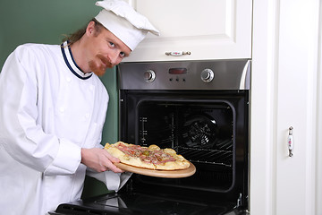 Image showing young chef with italian pizza in kitchen