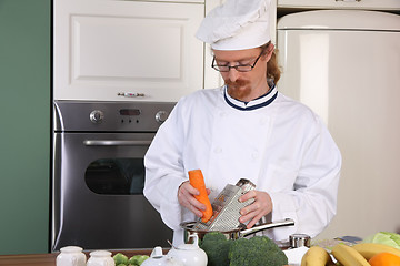 Image showing Young chef preparing lunch in kitchen