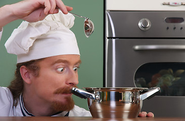 Image showing Funny young chef strange looking at pot