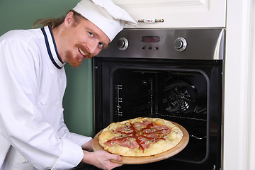 Image showing young chef with italian pizza in kitchen