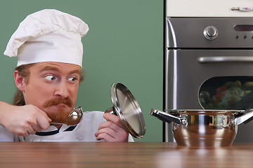 Image showing Funny young chef strange looking at pot