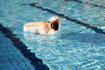 Image showing Young athletic man working out swimming in pool