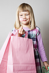 Image showing Little girl with shopping bags and lollipop